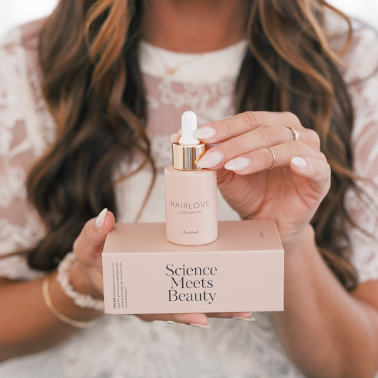 Hands holding a pink HAIRLOVE scalp serum bottle (1 fl oz (30 ml)) on a box labeled 'Science Meets Beauty'