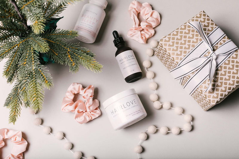 Flat lay of HAIRLOVE products including hair care items and a gift box, with a holiday theme.