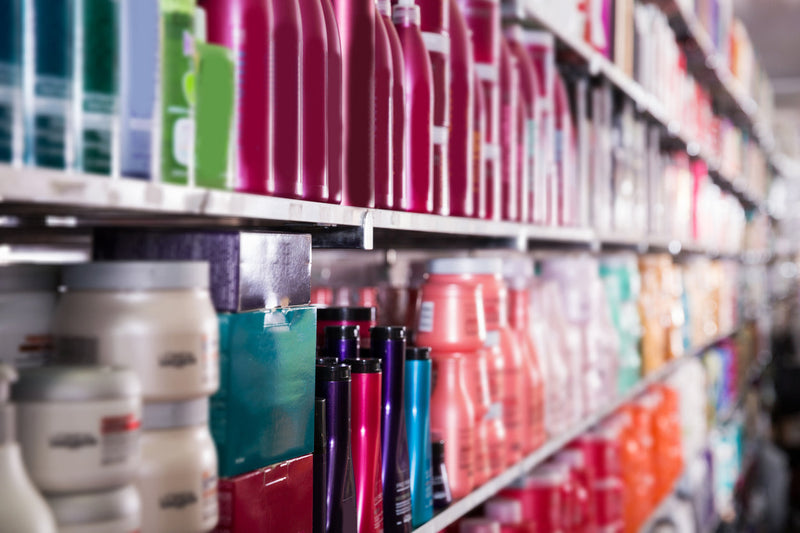 A variety of colorful hair care products on shelves in a store.