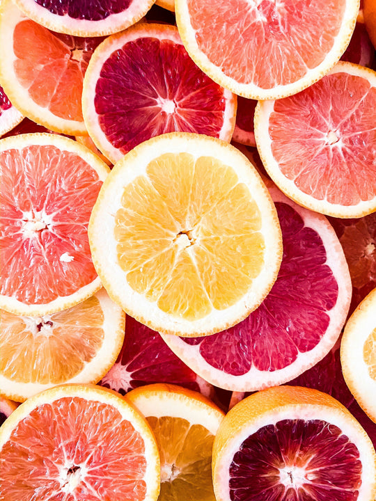 Close-up of assorted citrus fruit slices including grapefruit and orange, highlighting vitamin C rich foods for hair growth.