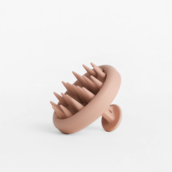 Angled view of Detox Scalp Massager showing soft silicone cone bristles and suction-cup handle on white background