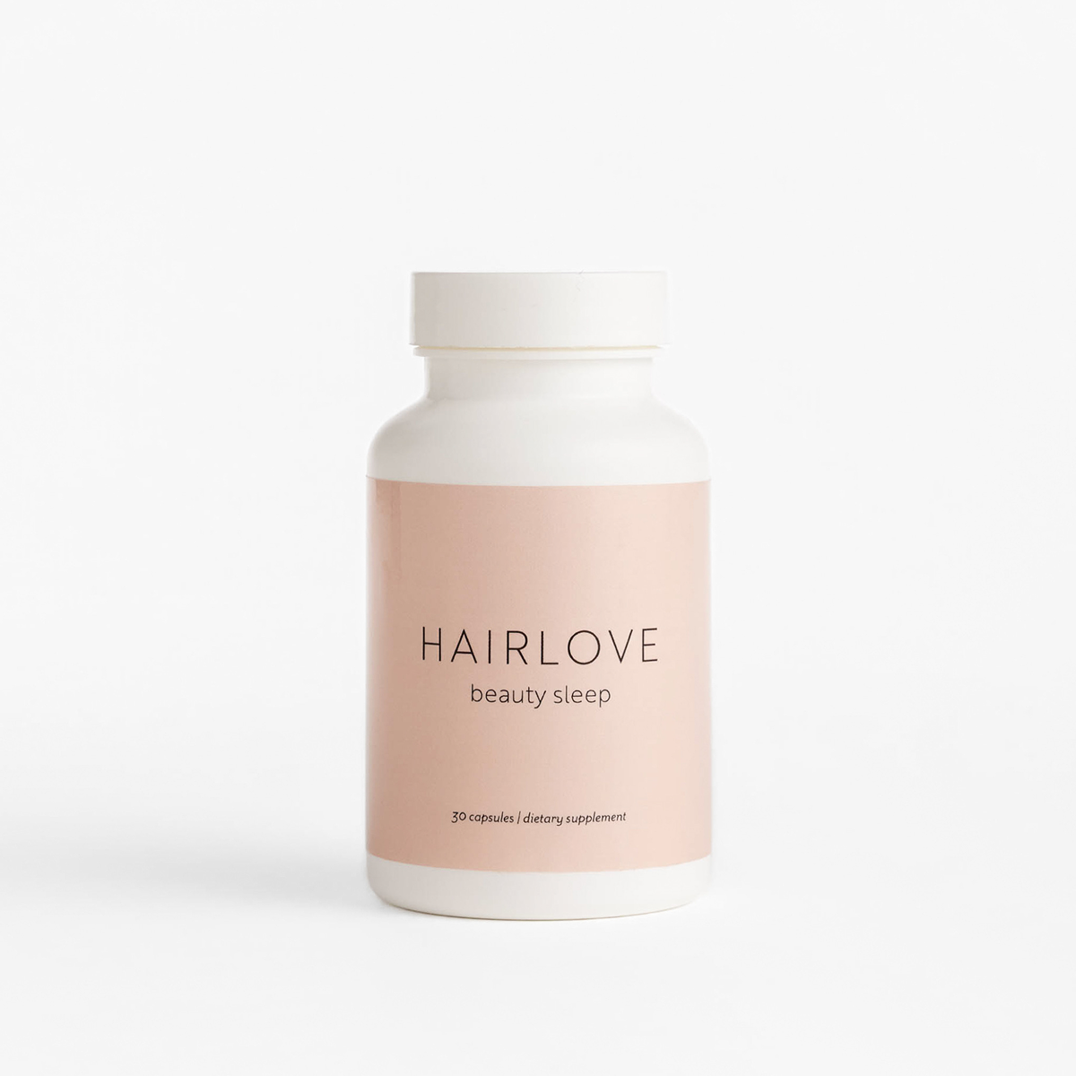 Front view of Beauty Sleep supplement bottle showcasing pale pink HAIRLOVE label reading “beauty sleep” on white background